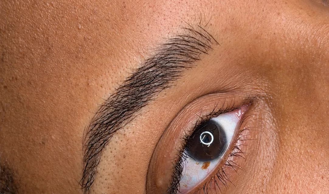 Close-up of microbladed brow strokes following natural hair growth
